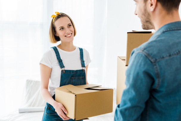 stock-photo-cheerful-couple-holding-cardboard-boxes-looking-each-other